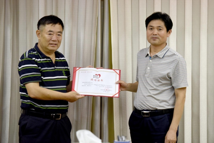 图为临泉县教育局局长柳洪明（右）为湖南东健药业有限公司颁发捐赠证书。记者蒋守福 摄.jpg