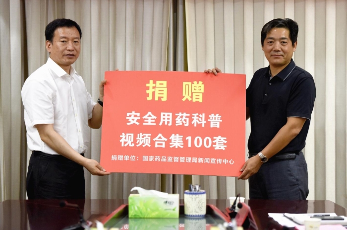 图为国家药品监管局新闻宣传中心副主任赵北海（左）向临泉县卫生健康委员会捐赠安全用药科普视频合集。记者蒋守福 摄.jpg
